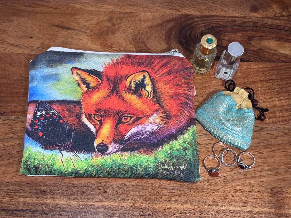 The fox pouch beside rings, a small silk pouch and two perfume bottles, showing its size.
