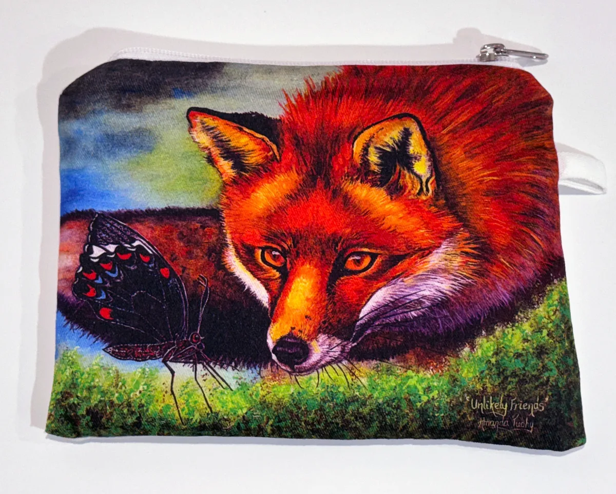 A zip-up cotton pouch printed with a red fox resting its chin on the grass, its golden eyes watching a black butterfly with red and blue spots beside it.