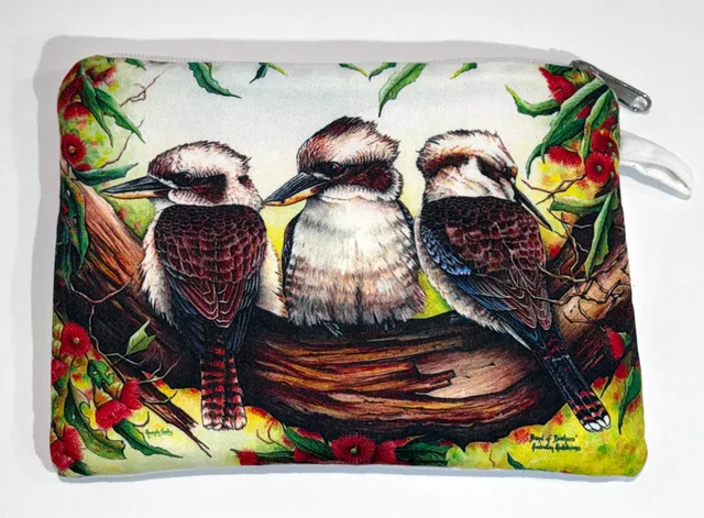 A zip-up cotton pouch printed with three kookaburras perched side by side on a gum branch, with red gum blossoms and green leaves around them.