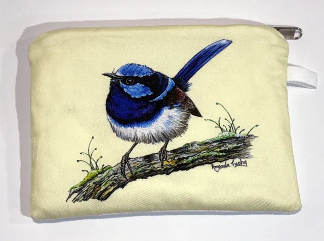 A pale yellow zip-up cotton pouch printed with a single wren in bright blue and black plumage, its tail cocked upright, perched on a mossy branch.