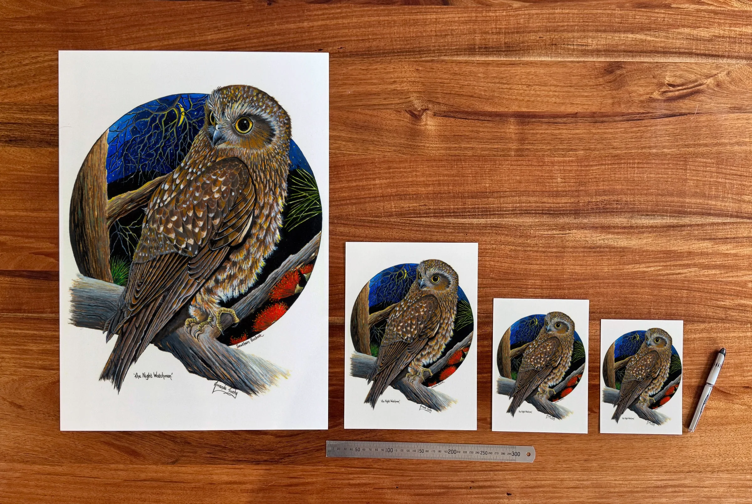 The Night Watchman at each available size: A2 (420 × 594 mm), A4, A5 and 5 × 7 in (127 × 178 mm), beside a 30 cm ruler. The 5 × 7 in print shows the whole painting, with white strips of about 11 mm top and bottom.