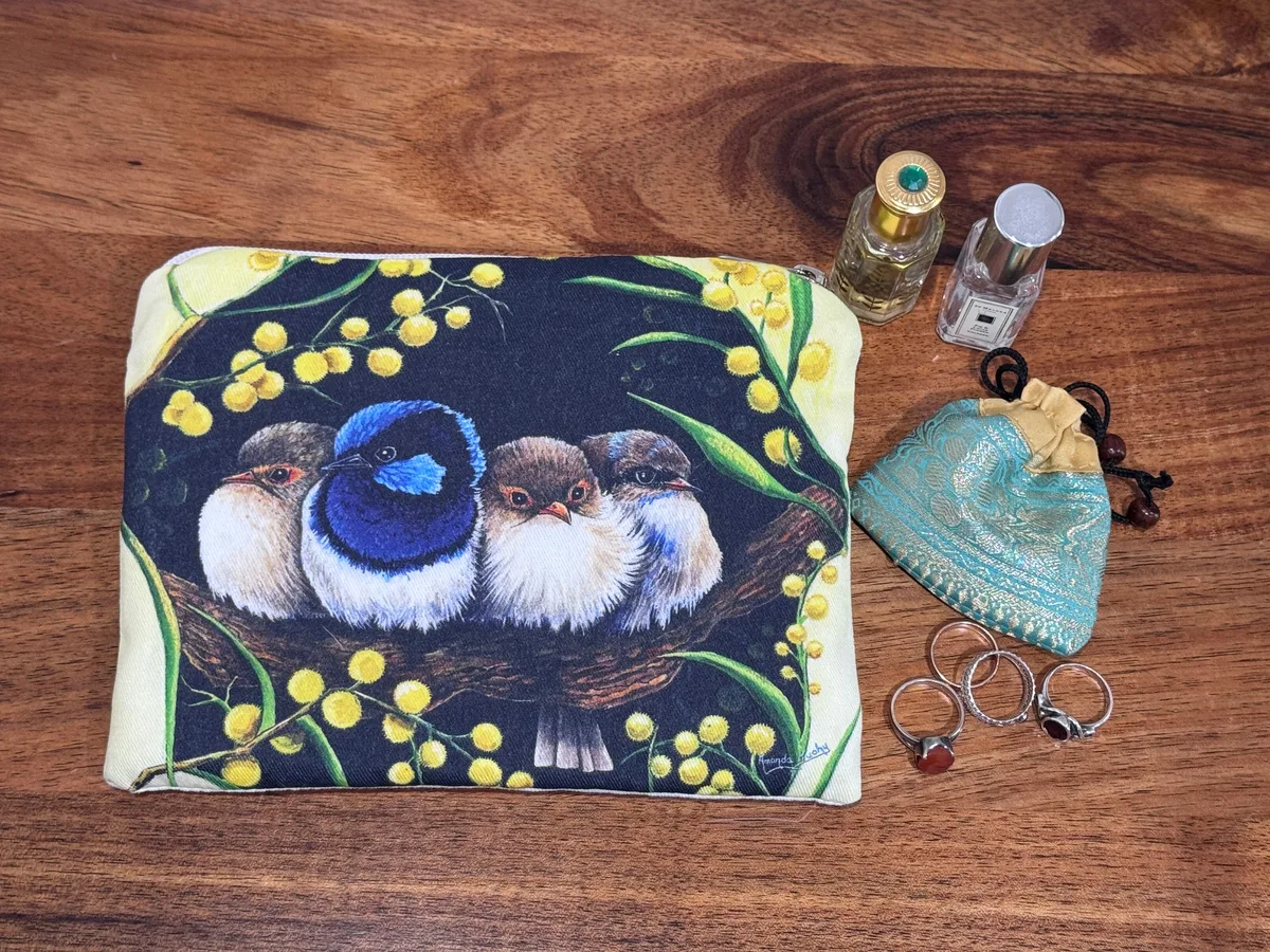 The wrens and wattle pouch beside rings, a small silk pouch and two perfume bottles, showing its size.